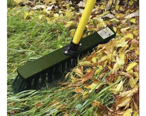 Lövkvast med gult handtag och grön borst som används på gräsmatta och löv