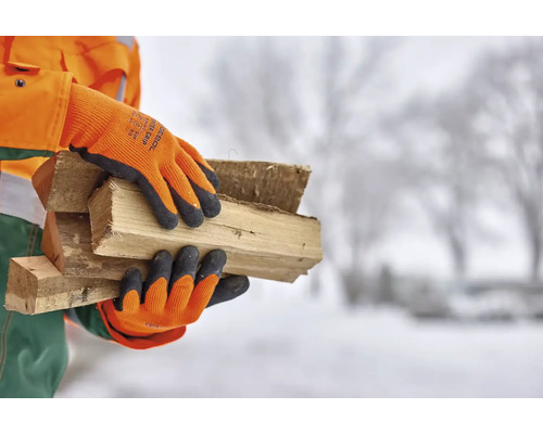 Person med arbetshandskar som bär vedträn