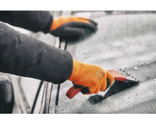 Person med handskar använder en isskrapa på en vindruta