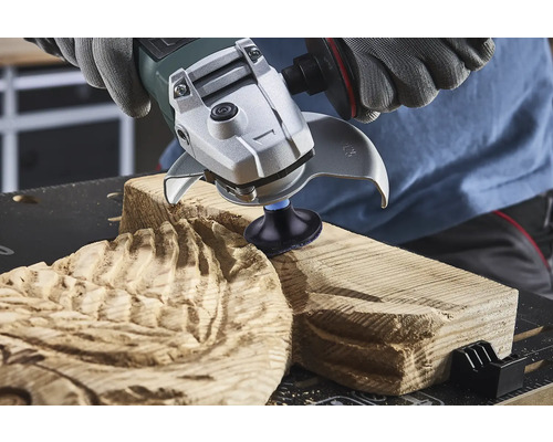 En person använder en vinkelslip för att bearbeta trä.
