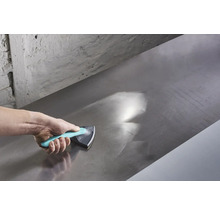 Hand som använder ett slipblock för att jämna ut en metallyta.