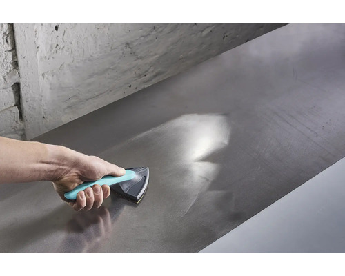 Hand som använder ett slipblock för att jämna ut en metallyta.