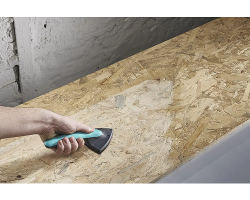 En hand håller ett slipkloss och slipar en träplanka.