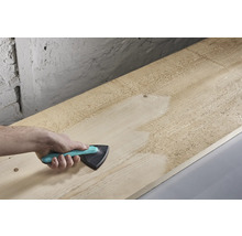 Hand slipar träplanka med triangelslipmaskin