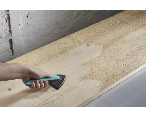 Hand slipar träplanka med triangelslipmaskin