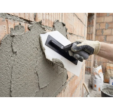 Putsning av en tegelvägg med en murslev