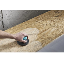 En person slipar en träskiva med en handhållen slipmaskin.