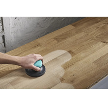 En person slipar en träskiva med en excenterslipmaskin.