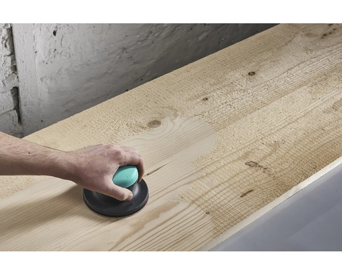 Handslipmaskin som används på en träplanka