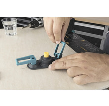 En man använder en hålsåg cirkelskärare på en träyta