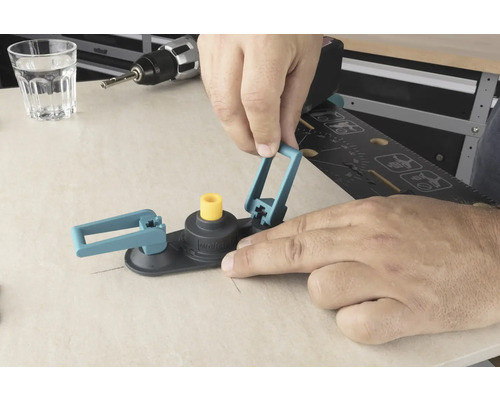 En man använder en hålsåg cirkelskärare på en träyta