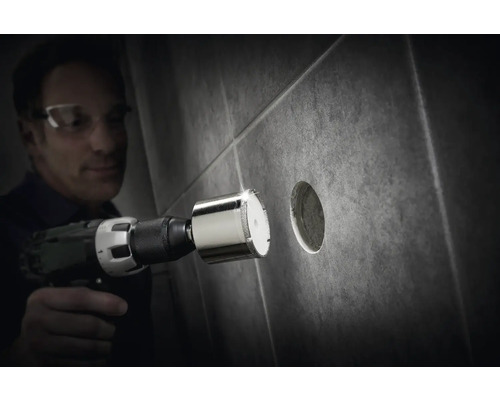 Man borrar ett hål i en kakelplatta med en diamantborrkrona.