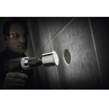 Man borrar ett hål i en kakelplatta med en diamantborrkrona.