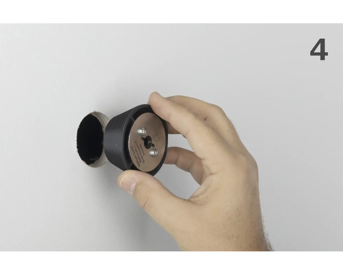 Hand som håller Wolfcrafts pluggborr framför borrhålet