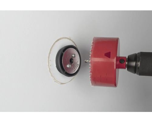 Borrmaskin med hålsåg skär ett hål i en vägg