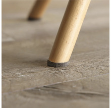 Närbild av ett stolsben med möbeltassar för att skydda golvet.