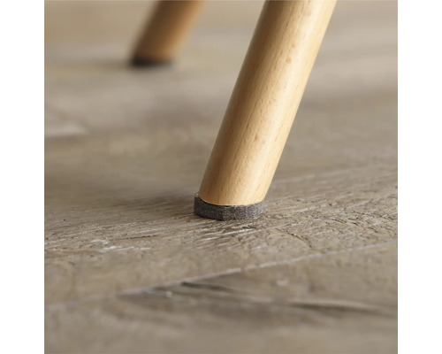 Närbild av ett stolsben med möbeltassar för att skydda golvet.