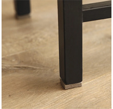 Detaljvy av ett svart möbelben med en glidfot i filt för att skydda golvet.