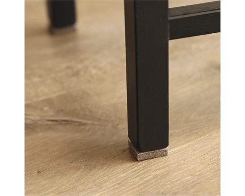 Detaljvy av ett svart möbelben med en glidfot i filt för att skydda golvet.