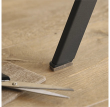 Filttass på ett stolsben med sax och bit filt på golvet