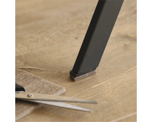 Filttass på ett stolsben med sax och bit filt på golvet