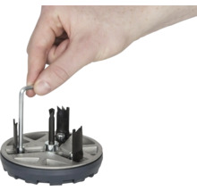 Hand manövrerar hålsåg med insexnyckel