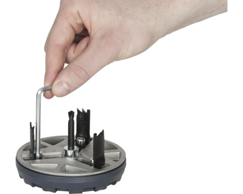 Hand manövrerar hålsåg med insexnyckel