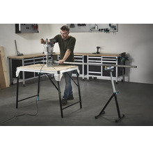 Man arbetar med en borrmaskin på ett arbetsbord, med verktyg och en arbetsbänk i bakgrunden.