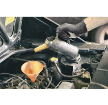 Motorolja fylls på med tratt och oljekanna