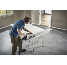 Hantverkare som sågar en dörr med en cirkelsåg på en arbetsbänk.