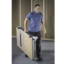 En man bär ett hopfällt arbetsbord.