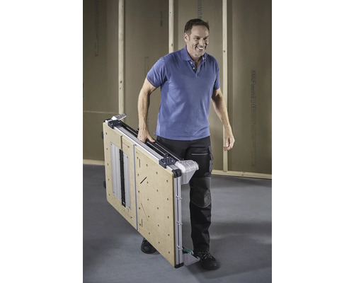 En man bär ett hopfällt arbetsbord.