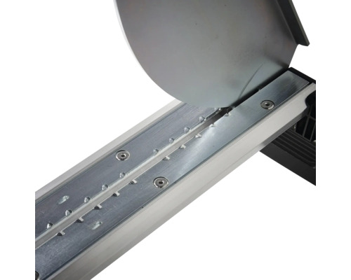 Detaljvy av en styrskena i metall för en kakelskärare med kapskiva.