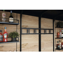 Hylla med drycker och dekoration framför en trävägg