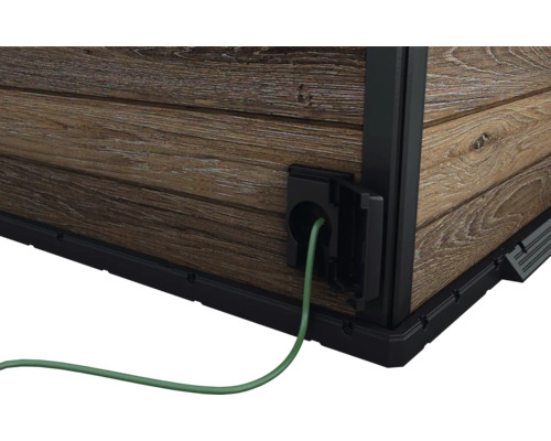 Detaljvy av ett trädgårdshus med elanslutning och kabel