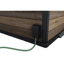 Detaljvy av ett trädgårdshus med elanslutning och trävägg