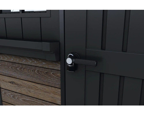 Närbild av en svart trädgårdsredskapsdörr med handtag