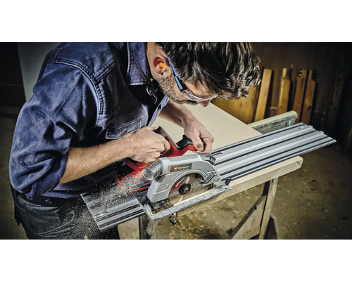 En man sågar ett arbetsstycke med en Einhell sänksåg.