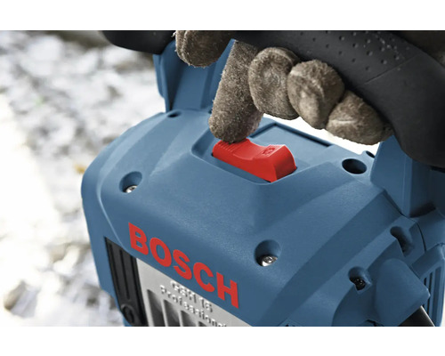 Hand med handske manövrerar den röda strömbrytaren på en blå Bosch bilningshammare.