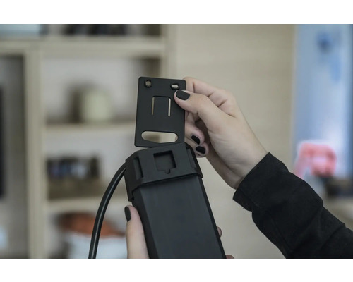 En person fäster ett fäste på en elektronisk enhet.