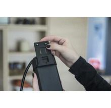 Person monterar ett fäste på en rulljalusimotor.