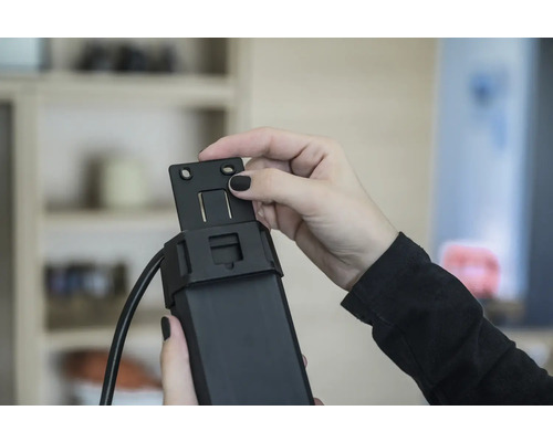 Person monterar ett fäste på en rulljalusimotor.