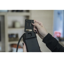 En person fäster ett fäste på en elektronisk enhet.