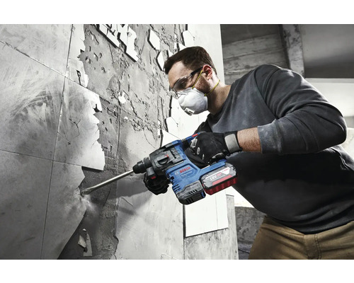 En man tar bort plattor med en borrhammare från Bosch.