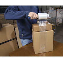 Man packar kartonger med sträckfilm