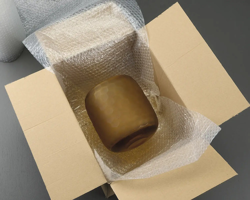 Brun glasvas i en kartong med bubbelplast