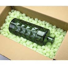 Dekorativ glasflaska i en kartong med förpackningschips