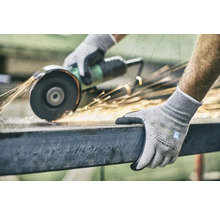 En person slipar metall med en slipmaskin och bär arbetshandskar.