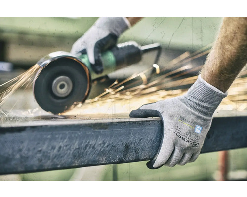 En person slipar metall med en slipmaskin och bär arbetshandskar.