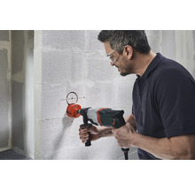 Man borrar ett hål i en vägg med en hålsåg